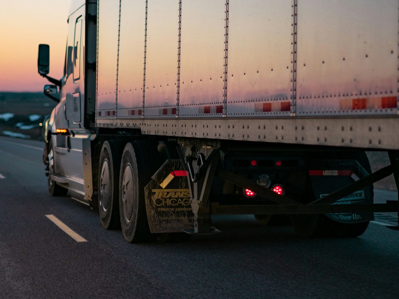Transport truck and trailer on the highway at sunset