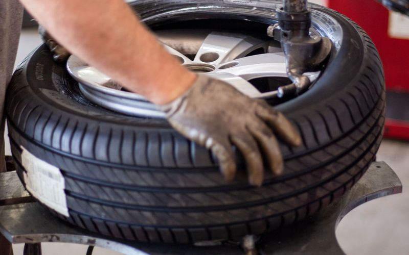 Technician mounting a tire on a tire changer machine